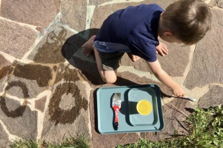 Kind malt mit Wasser - ein Spiel, das nicht viel Material benötigt
