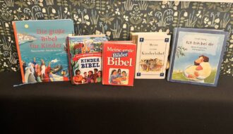 Fünf Kinderbibeln für Kinder ab 3 Jahren nebeneinander auf einem Tisch