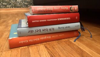 Vier empfohlene Kinderbibeln als Bücherstapel auf einem Tisch