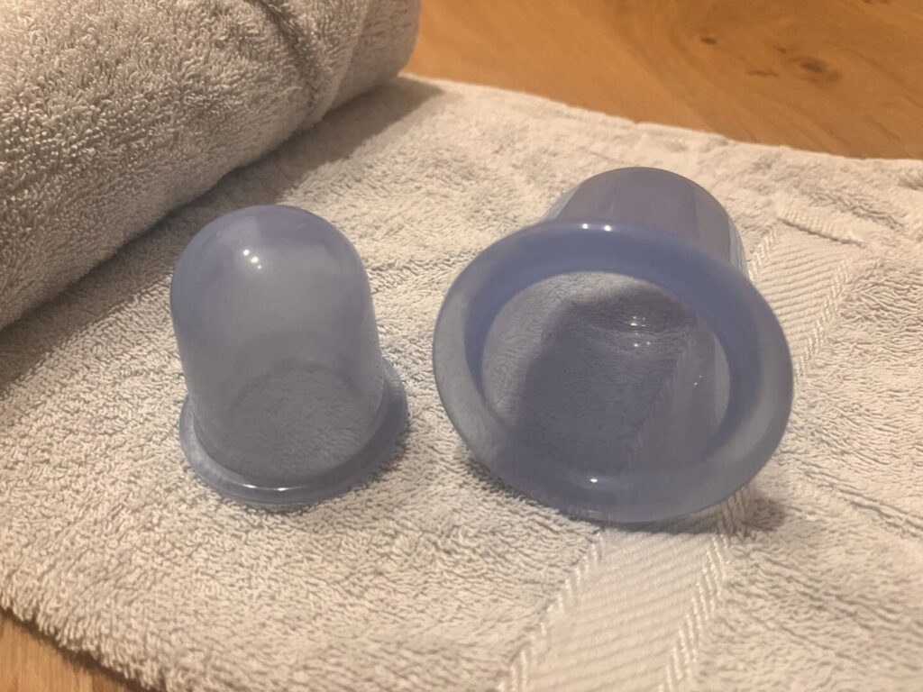 Zwei blaue Silikon-Cups in verschiedenen Größen auf einem Handtuch