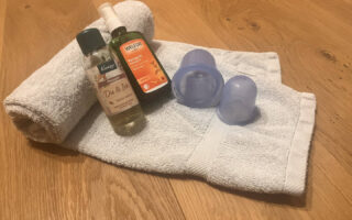 Silikon-Cups und Massageöl auf einem Handtuch – Material zum Schröpfen zuhause