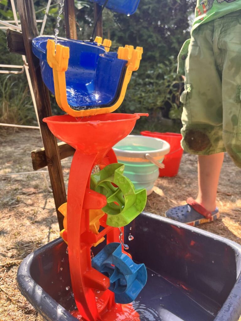 Wasserrad dreht sich in der selbstgebauten Wasserfall-Bahn – Wasserspiel für Kindergartenkinder